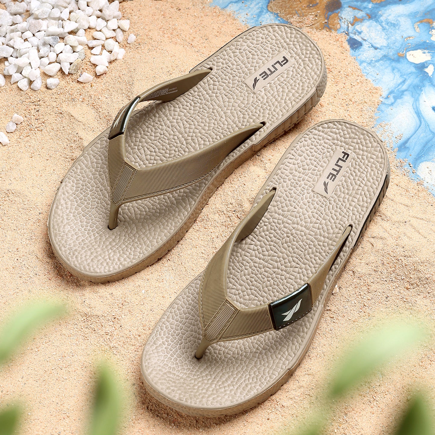 Front upper side image of A close up slight high angle shot of single color men's flip flop sandal by flite. The sandal has a textured, slightly bumpy footbed and a thick durable looking sole. The thong strap is wide an also textured with horizontal ridges. 