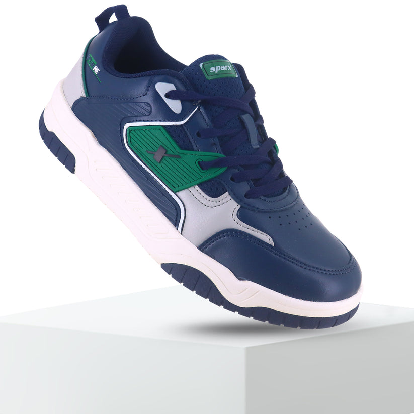 Back side is up Image of Sneakers for Men by Sparx , blue sneaker with green logo of sparx writing X on it and the bottom is white with non slip grip of blue comfortable to wear for men of all age and affordable. 