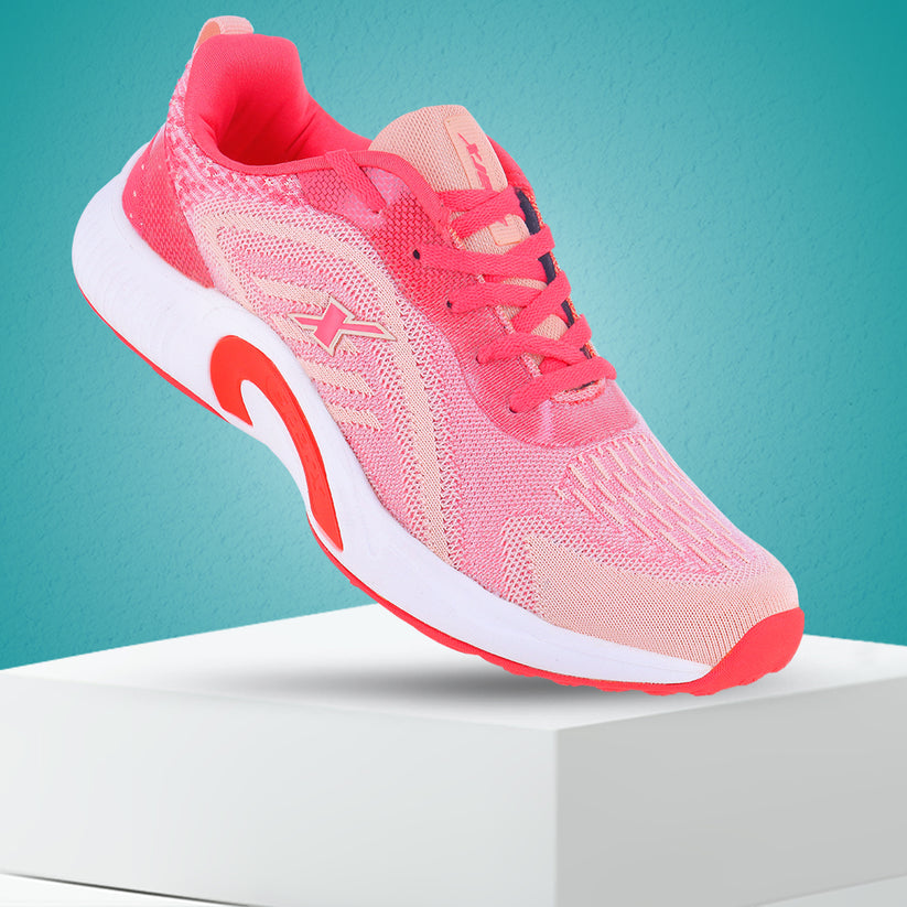 Backside up, front is down touching the bottom. Image of women's athletic shoe in shades of pink and coral, with a white sole and a prominent "X" logo on the side. By Sparx and white background available.